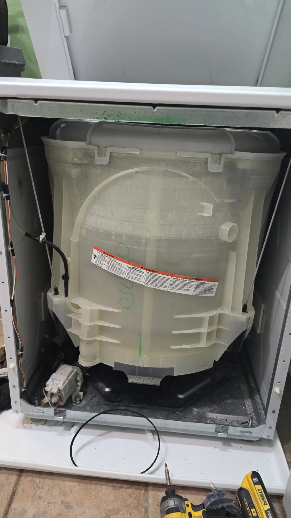 Opened washer section of a GE laundry center during drive-belt repair