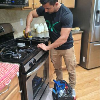 foreman cleaning the gas stove in the client's house