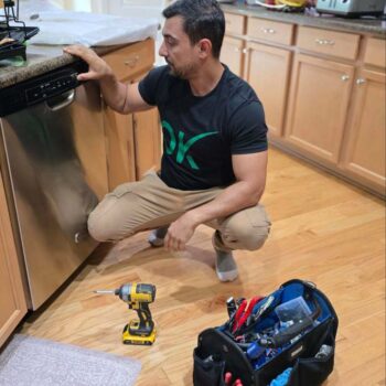 a craftsman fixes a dishwasher at the customer's home