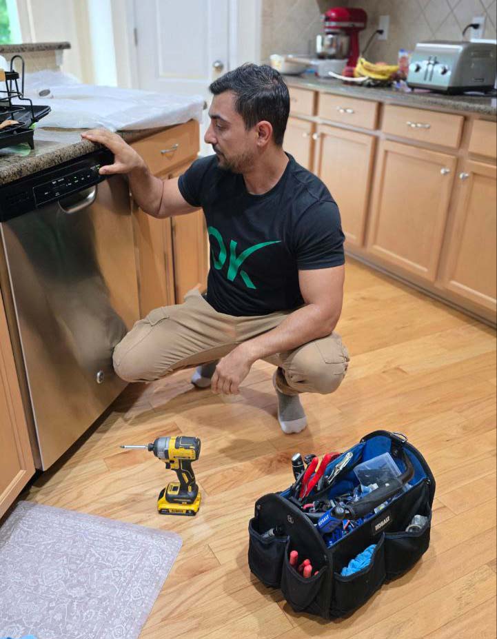 a craftsman fixes a dishwasher at the customer's home